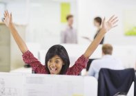 Businesswoman cheering at desk at modern office — Stock Photo