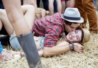 Casal beijando na grama no festival de música — Fotografia de Stock