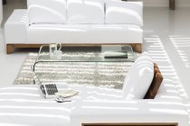 Ноутбук, диваны и журнальный столик в современной гостиной — стоковое фото