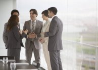 Business people talking at window of conference room — Stock Photo