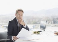 Businessman with lunch reviewing paperwork — Stock Photo