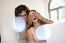 Homem cobrindo olhos namorada dentro de casa — Fotografia de Stock