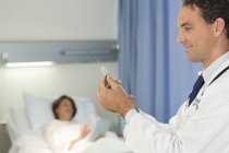 Médico verificando seringa no quarto do hospital — Fotografia de Stock