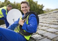 Abili lavoratori caucasici che installano parabole satellitari sul tetto — Foto stock