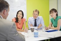 Gente de negocios hablando en la reunión en la oficina moderna - foto de stock
