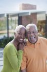 Older couple smiling outdoors — Stock Photo
