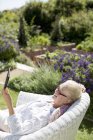 Seniorin nutzt digitales Tablet im Garten — Stockfoto