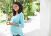 Беременная женщина ест салат — стоковое фото