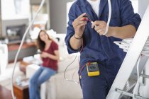 Skillful electrician working in living room — Stock Photo