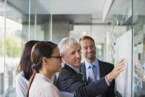 Empresários discutindo documentos em prédio de escritórios — Fotografia de Stock