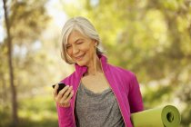 Older woman using cell phone outdoors — Stock Photo