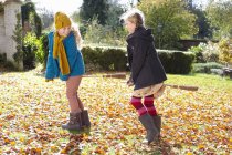 Girls playing together in autumn leaves — Stock Photo
