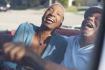 Пожилая пара смеется в кабриолете — стоковое фото