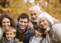 Family smiling together in park — Stock Photo