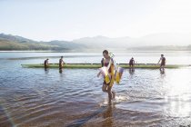 Squadra canottaggio con remi e teschio sul lago — Foto stock