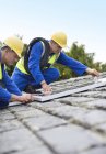 Trabalhadores que instalam painéis solares no telhado — Fotografia de Stock