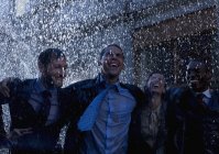 Glückliche multirassische rnthusiastische Geschäftsleute im Regen — Stockfoto
