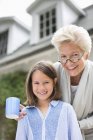 Frau und Enkelin lächeln gemeinsam im Freien — Stockfoto