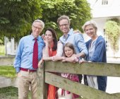 Family smiling together by wooden fence — Stock Photo