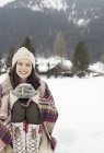 Портрет улыбающейся женщины, пьющей кофе на снежном поле — стоковое фото