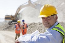 Businessman wearing hard hat in quarry — Stock Photo