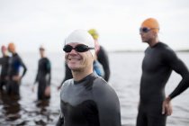 Triatleta seguro y fuerte sonriendo en la playa - foto de stock