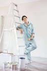 Skillful caucasian woman smiling and painting room — Stock Photo