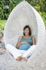 Беременная женщина отдыхает на открытом воздухе — стоковое фото