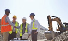 Business people shaking hands in quarry — Stock Photo