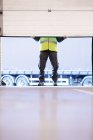 Worker lifting door in warehouse — Stock Photo