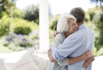 Sénior casal caucasiano abraçando no pátio — Fotografia de Stock