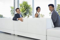 Geschäftsleute lächeln auf Sofa im modernen Büro — Stockfoto