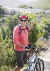 Confiado ciclista de montaña caucásico en camino de tierra - foto de stock