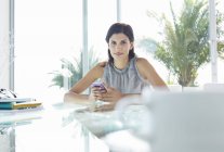 Geschäftsfrau nutzt Handy im modernen Büro — Stockfoto