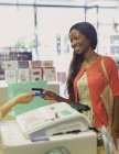Frau bezahlt mit Kreditkarte in Drogerie — Stockfoto
