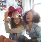 Young happy women playing with hats in bedroom — Stock Photo