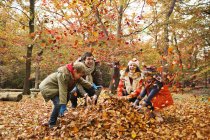 Famiglia felice che gioca in foglie di autunno — Foto stock