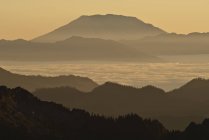 Silhouette des Berges über nebliger Landschaft — Stockfoto