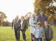 Happy family walking together in park — Stock Photo