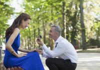 Uomo con anello di fidanzamento che propone alla fidanzata nel parco — Foto stock