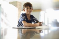 Junge macht Hausaufgaben am Schalter — Stockfoto