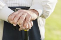 Close up of older man's hands on cane — Stock Photo