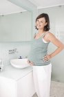 Pregnant woman standing in bathroom — Stock Photo