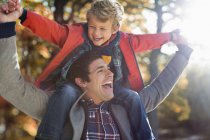 Father carrying son in park — Stock Photo