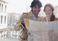Coppia sorridente che guarda la mappa a Venezia — Foto stock