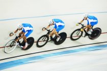 Track cycling team racing in velodrome — Stock Photo
