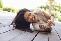 Frau benutzt Handy auf Holzdeck — Stockfoto