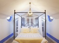 Люстра над чотирма постерними ліжками в розкішній спальні — стокове фото