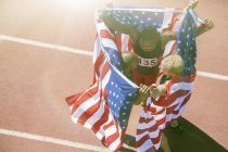 Atletas de pista e campo segurando bandeiras americanas na pista — Fotografia de Stock