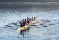 Squadra canottaggio che celebra in scull sul lago — Foto stock